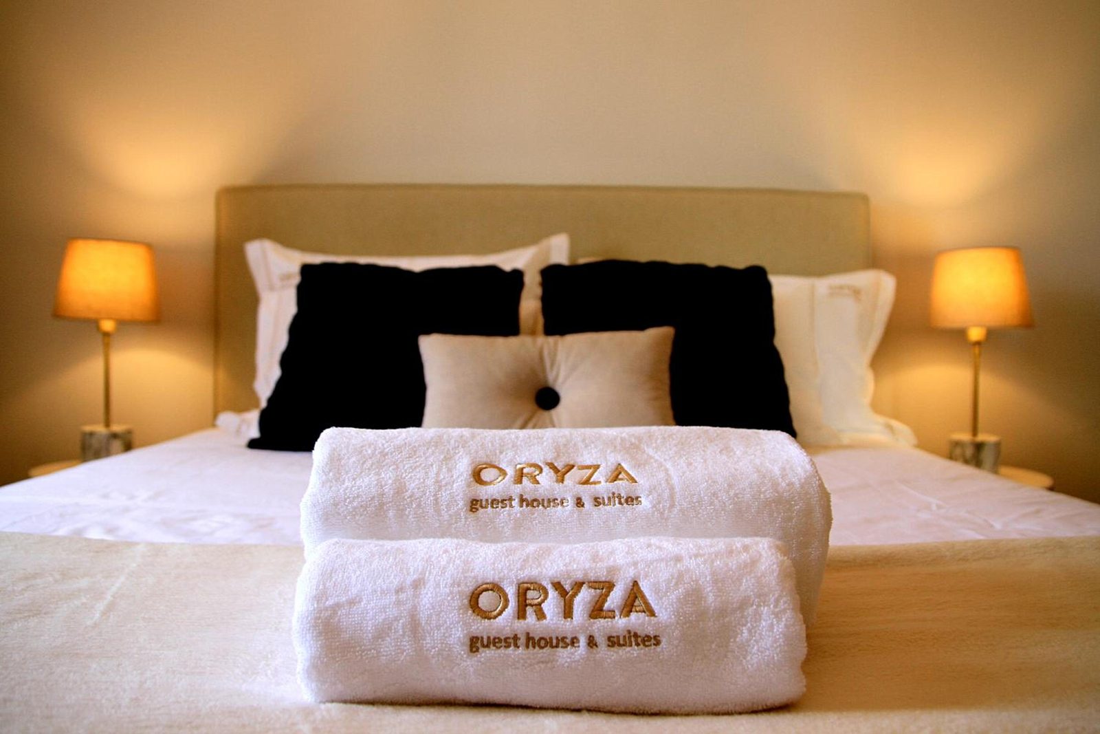 Toalhas bordadas com o nome Oryza sobre a cama