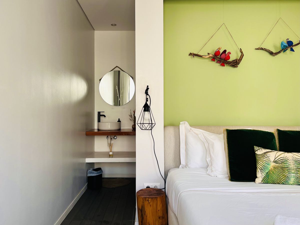O quarto, com o espelho redondo e o lavatório ao lado da cama