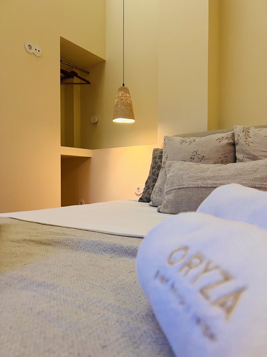 Toalha bordada com o nome Oryza sobre a cama