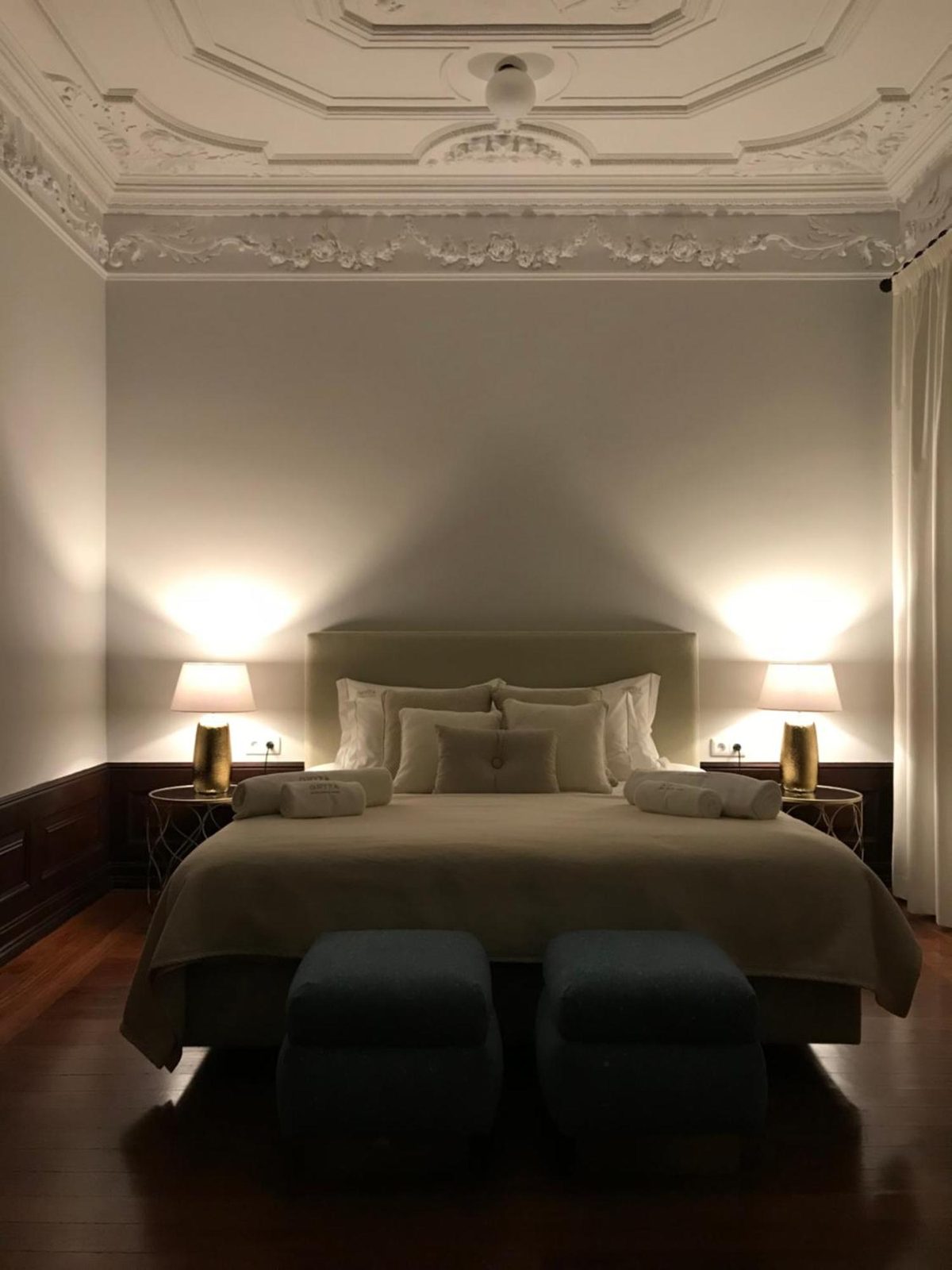 A cama king sob o teto de estuque trabalhado